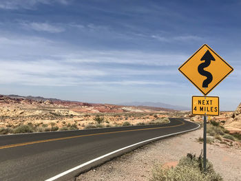 Road sign against sky