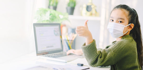 Portrait of girl using laptop on table