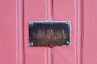 Close-up of mailbox on pink door