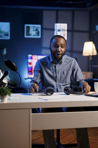 Portrait of young man sitting on table