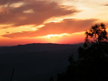 Scenic view of silhouette mountains against orange sky