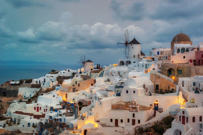 Buildings in city against cloudy sky