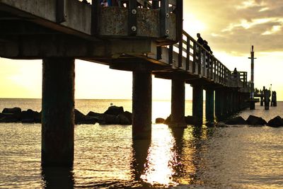 Pier on sea at sunset