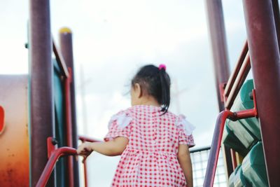 Rear view of girl standing on slide