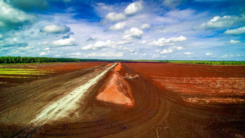 Road amidst field against sky