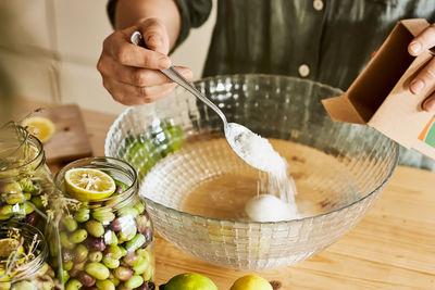 Woman prepares fermented olives in glass jars in the kitchen. autumn vegetables canning.