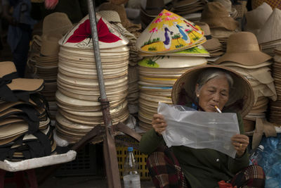 Portrait of a woman at local market selling hats