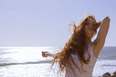 Red haired woman on windy beach