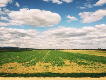 Scenic view of field against cloudy sky