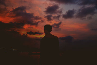 Silhouette man standing against orange sky