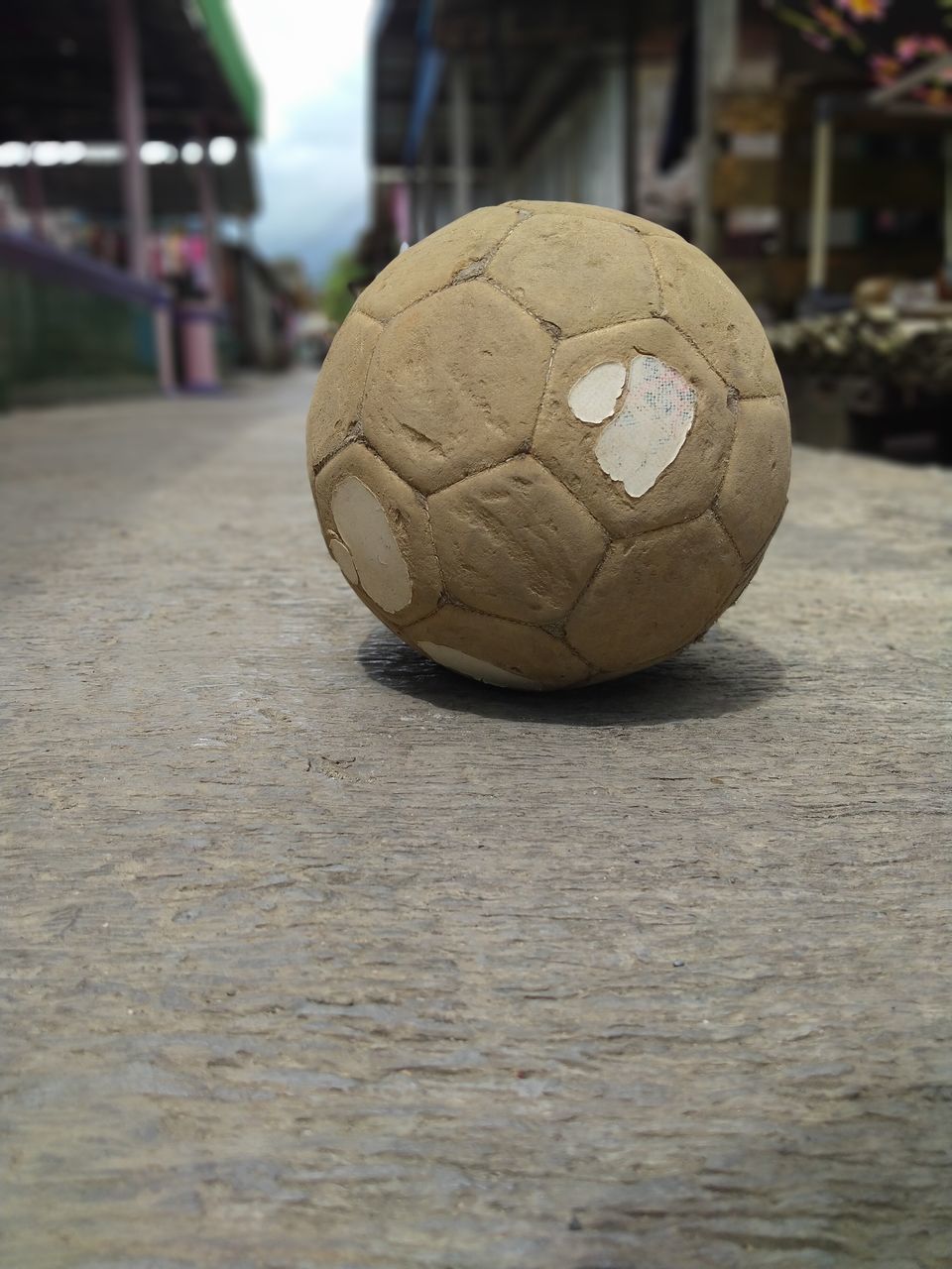 CLOSE-UP OF SOCCER BALL ON STREET LIGHT AT CITY
