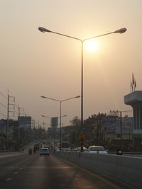 Traffic on road at sunset