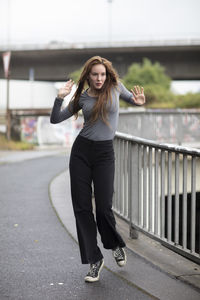 Portrait of young woman standing in city