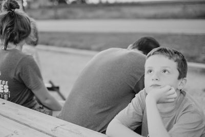 Close-up of siblings sitting outdoors