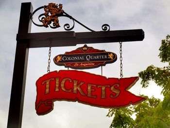 Low angle view of information sign against sky