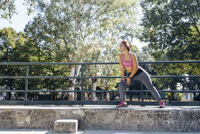 Young sportswoman stretching in the park