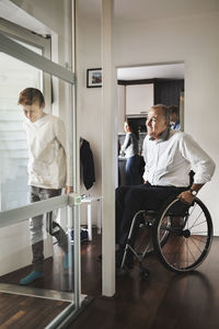 Son and father entering wheelchair lift at home