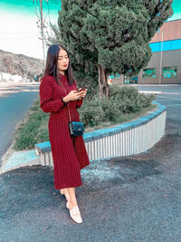 Full length of woman standing on mobile phone