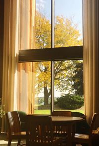 Empty chairs and table against window