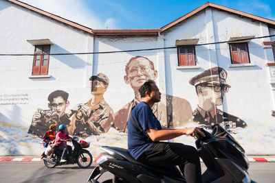 People riding motorcycle on street in city