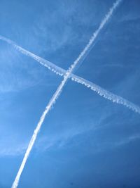 Low angle view of vapor trail against blue sky