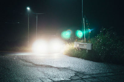 Illuminated street light on road at night