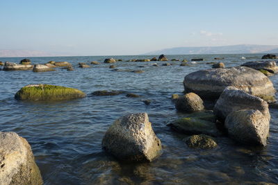 Rocks in sea against sky