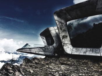 Low angle view of abandoned vehicle on field against sky