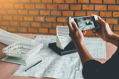 Midsection of woman using mobile phone on table