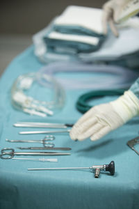 Cropped hands of person by surgical equipment on table