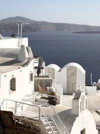 Houses by sea against clear sky