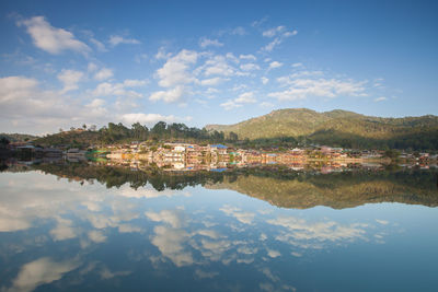 Scenic view of lake by mountains against sky