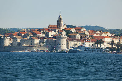 View of townscape by sea against clear sky