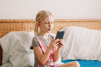 Teenage girl using mobile phone at home