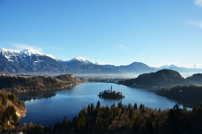 Scenic view of lake and mountains against blue sky