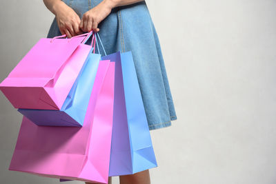 Midsection of woman holding multi colored umbrella