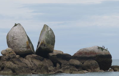 Rocks on beach against sky