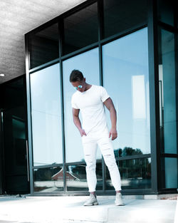 Full length of man standing by window on building