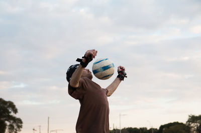 Low angle view of man playing soccer outdoors