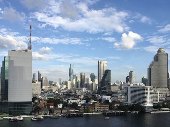 Modern buildings in city against cloudy sky