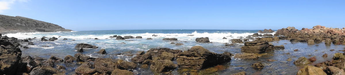 Panoramic view of sea against clear blue sky