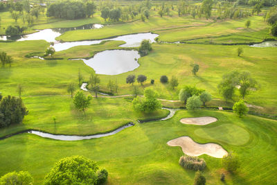 High angle view of golf course by lake