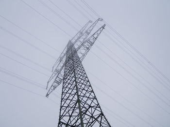 Low angle view of electricity pylon against clear sky