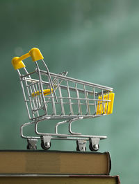 Close-up of toy shopping cart on books