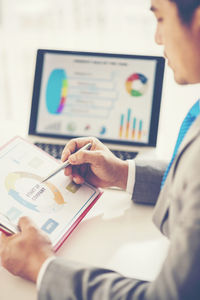 Businessman analyzing graph at desk in office