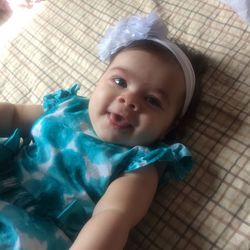 High angle view of cute baby girl lying on bed at home