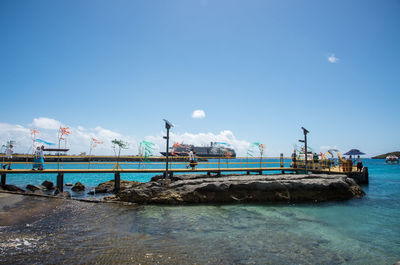 Ship moored at harbor against blue sky