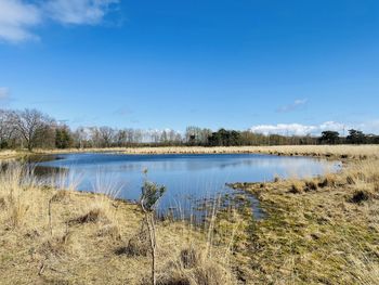 Scenic view of lake against blue sky