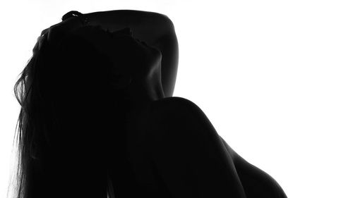 Rear view of silhouette woman against white background