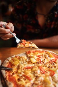 Midsection of woman holding pizza